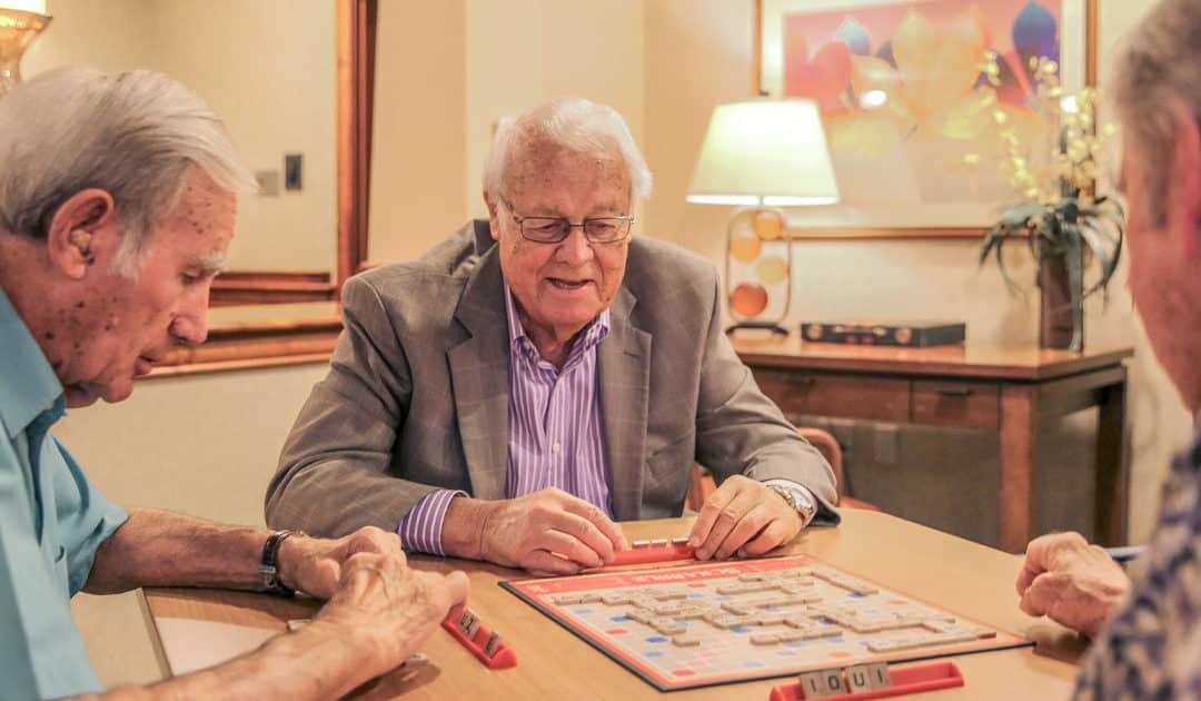 Three men play a board game at a table